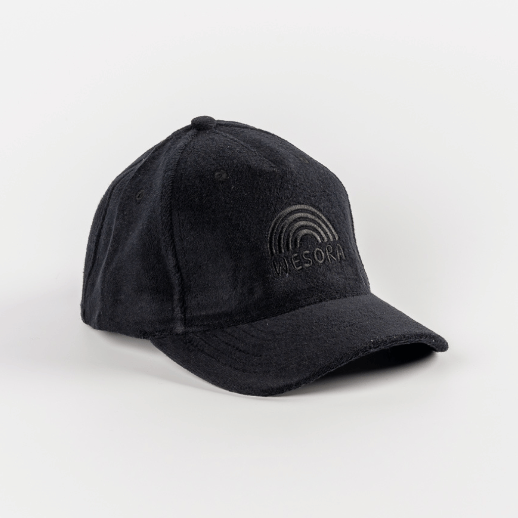 Frottee Cap - All Black mit Regenbogenmotiv und WESORA Stickerei, aus weichem Frottee, präsentiert auf weißem Hintergrund, zeigt minimalistisches Design.
