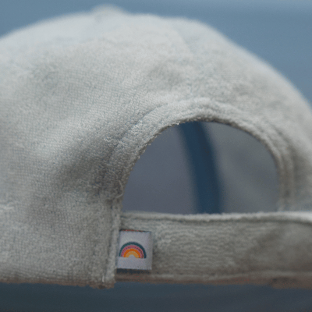 Frottee Cap - Fresh Mint mit Regenbogenlabel, fotografiert in einem Outdoor-Kontext, zeigt das saugfähige Material und den verstellbaren Klettverschluss für optimalen Sitz.