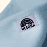 Eltern + Kind Bundle - Fleece Neckwarmer Baby Blue mit weichem Stoff und WESORA-Label, Nahaufnahme des Designs.