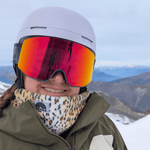Printed Neckwarmer - Fluffy Wild Leo mit Leopardenmuster, getragen von Wintersportler auf schneebedecktem Berg, fotografiert aus seitlicher Perspektive.
