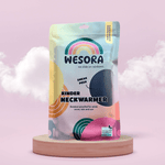 Fleece Neckwarmer -All Black Kid mit Recycling-Label, präsentiert auf Holzpodest vor rosa Hintergrund, mit Vorschaufenster für Produktansicht. Ideal für Outdoor-Abenteuer.