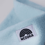 Fleece Neckwarmer - Candy Rose Kid mit blauem, flauschigem Stoff und WESORA-Label, Nahaufnahme. Ideal für Abenteuer im Freien, kuschelig und handgemacht.