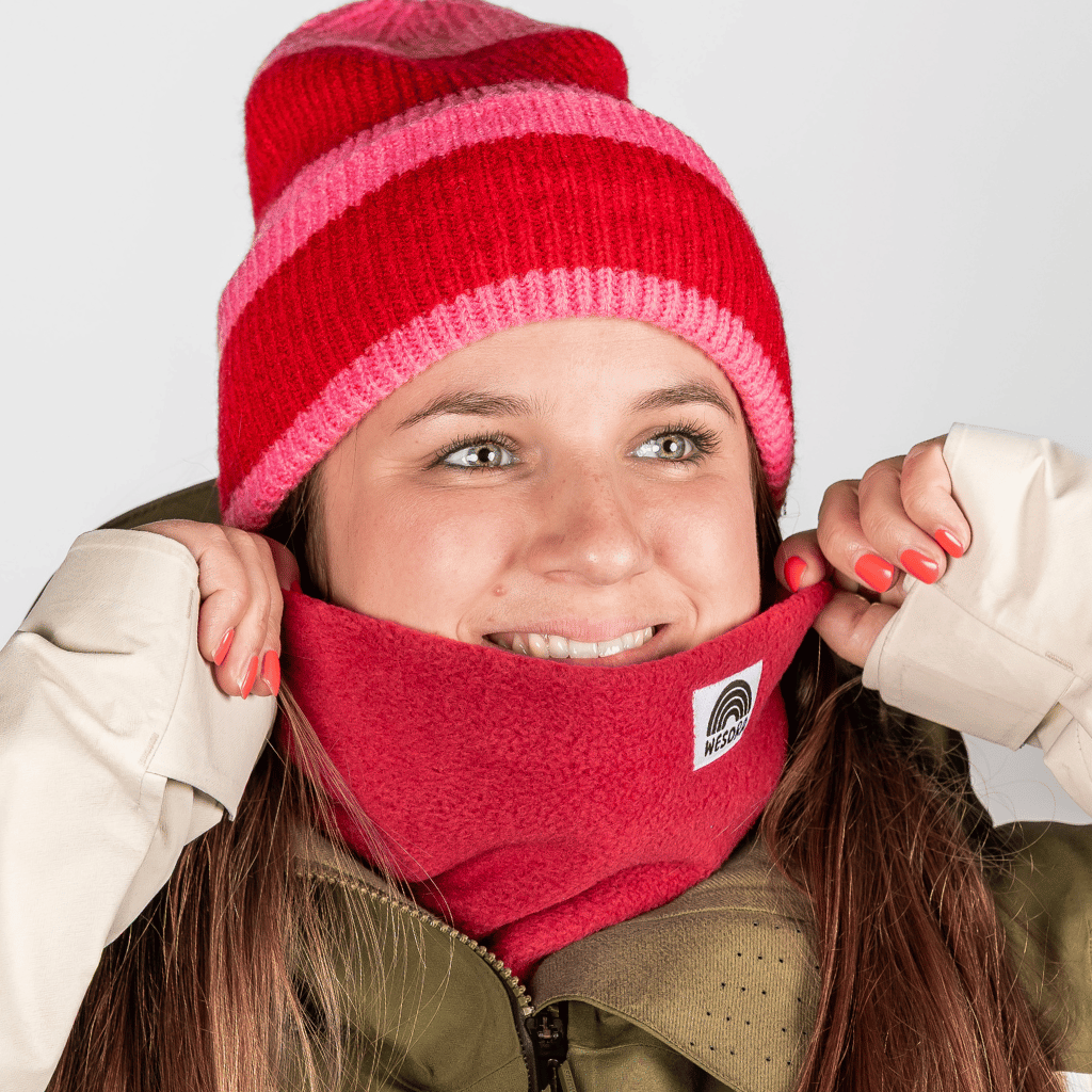Fleece Neckwarmer - Frosty Bordeaux in tiefem Rot, getragen von einer lächelnden Person mit passender Mütze und Jacke, Nahaufnahme.