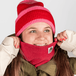 Fleece Neckwarmer - Frosty Bordeaux in tiefem Rot, getragen von einer lächelnden Person mit passender Mütze und Jacke, Nahaufnahme.