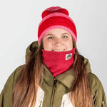 Beanie - Pink Berry Twist mit rot-pinken Streifen, getragen von Person mit langem braunem Haar, lächelnd in Winterkleidung, Nahaufnahme.