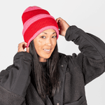 Beanie - Pink Berry Twist mit gestreiftem Strickdesign, getragen von Person mit schwarzer Jacke, frontal fotografiert.