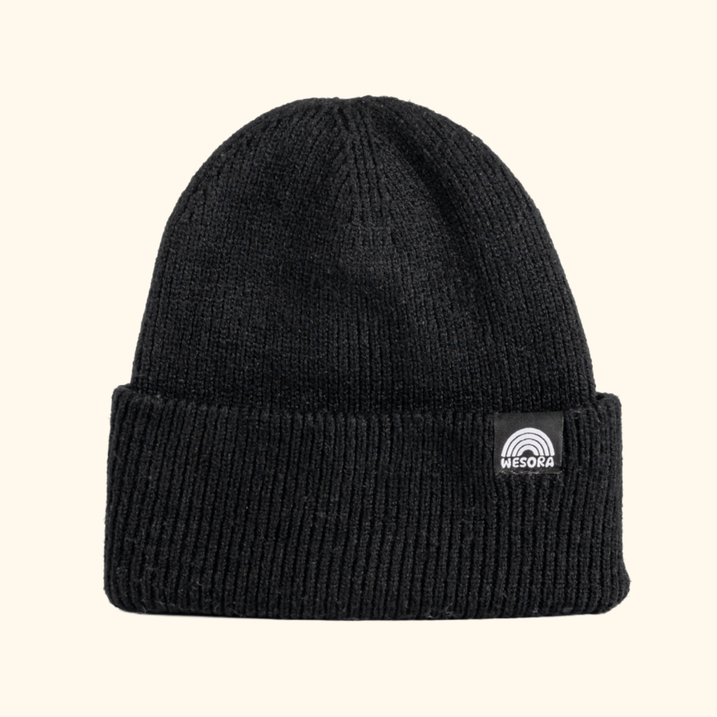 Beanie - All Black mit doppellagigem Rippstrick und breitem Umschlag, verziert mit WESORA-Label, fotografiert aus der Seitenperspektive.
