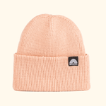 Beanie - Peach Fuzz mit geripptem Strickdesign und breitem Umschlag, WESORA-Logo auf schwarzem Etikett, gefaltet.