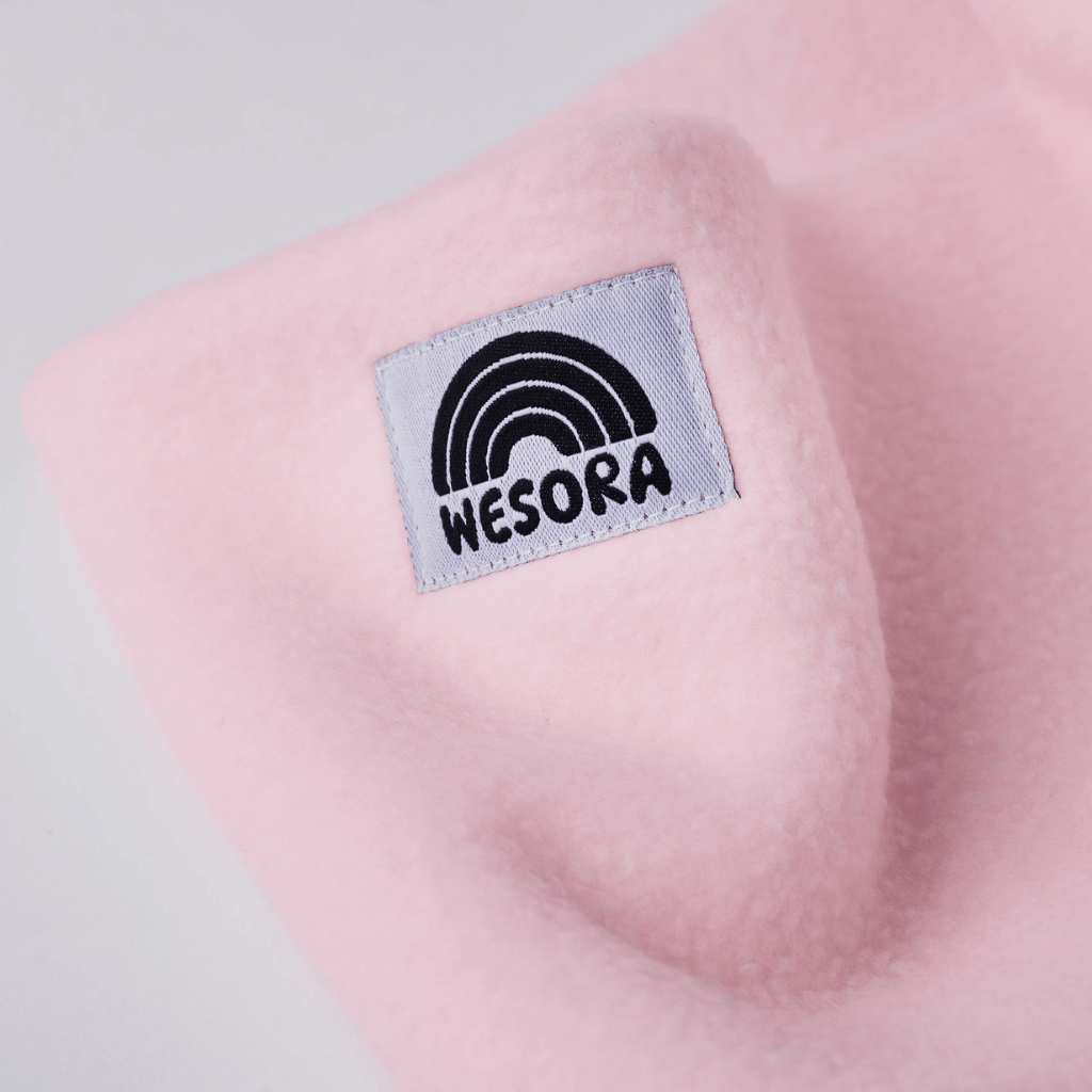 Fleece Neckwarmer - Candy Rose Kid mit WESORA-Logo und schwarzem Regenbogen, sanftes Rosa, ideal für Abenteuer, hält warm und strahlt Freundlichkeit aus.