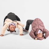 Fleece Neckwarmer - Dreamy Lilac Kid, getragen von einem lachenden Kind in Brückenpose, neben einem Freund, die spielerisch ihre Flexibilität zeigen.