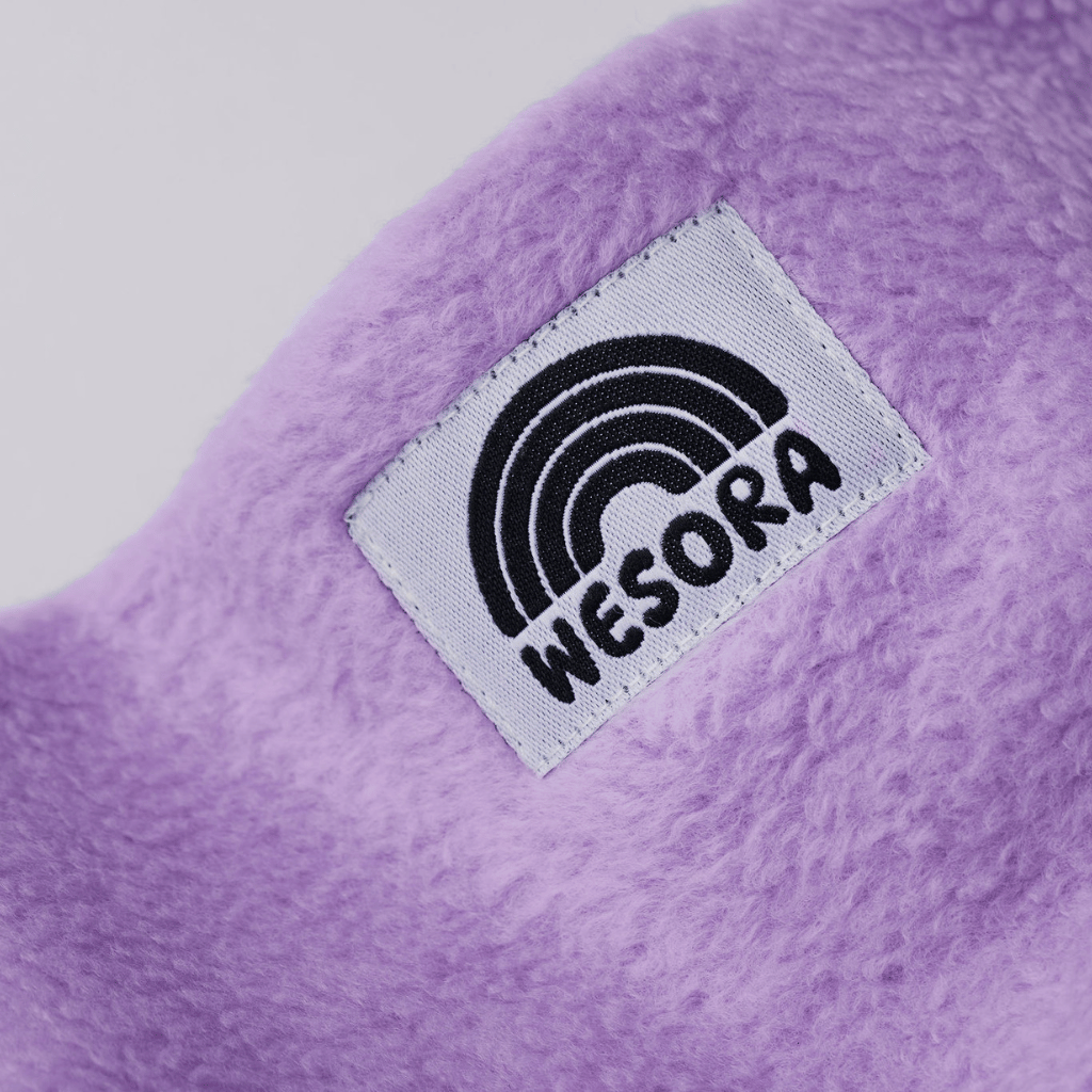 Fleece Neckwarmer - Dreamy Lilac Kid mit weichem, lila Stoff und WESORA-Label, ideal für winterliche Abenteuer und fantasievolle Momente.