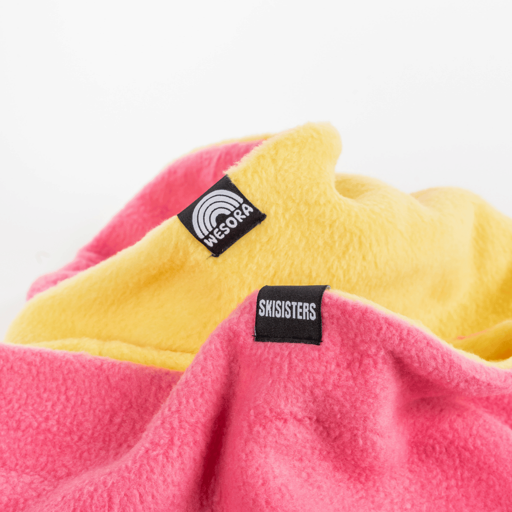 Fleece Neckwarmer - Skisister Edition 2 mit WESORA-Label, lebendig und stylisch in Pink und Gelb, ideal für farbenfrohe Abenteuer.