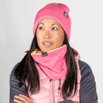 Fleece Neckwarmer - Skisister Edition 2 mit kontrastierendem Innenfutter, getragen von einer Frau mit langem dunklem Haar und rosa Mütze, Ansicht von vorne.