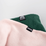 Fleece Neckwarmer - Skisister Edition 1 mit WESORA und SKISISTERS Etiketten, flach auf hellem Hintergrund liegend.