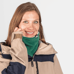 Fleece Neckwarmer - Skisister Edition 1, getragen von lächelnder Frau, betont Balance und Stärke, ideal für Abenteuer. Fotografiert vor neutralem Hintergrund.