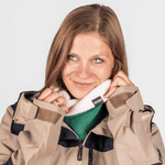 Fleece Neckwarmer - Skisister Edition 1 mit zweifarbigen Design, getragen von junger Frau, die den Kragen anpasst, fotografiert vor grauem Hintergrund.