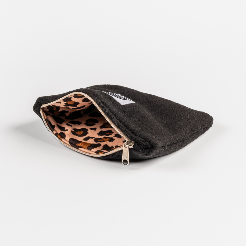 Fleece Zip Bag - All Black mit Leopardenmuster-Innenfutter, geöffnet auf weißer Fläche, zeigt nachhaltige Handwerkskunst von WESORA.