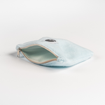 Fleece Zip Bag - Baby Blue aus flauschigem Stoff mit mintgrünem Innenfutter und beigem Reißverschluss, handgefertigt aus Stoffresten, liegend fotografiert.