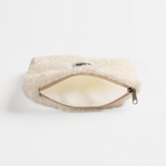 Fluffy Zip Bag - White, cremefarbene Kunstfell-Tasche, liegt auf weißem Hintergrund, mit leicht geöffnetem Reißverschluss, zeigt leeres, helles Inneres.
