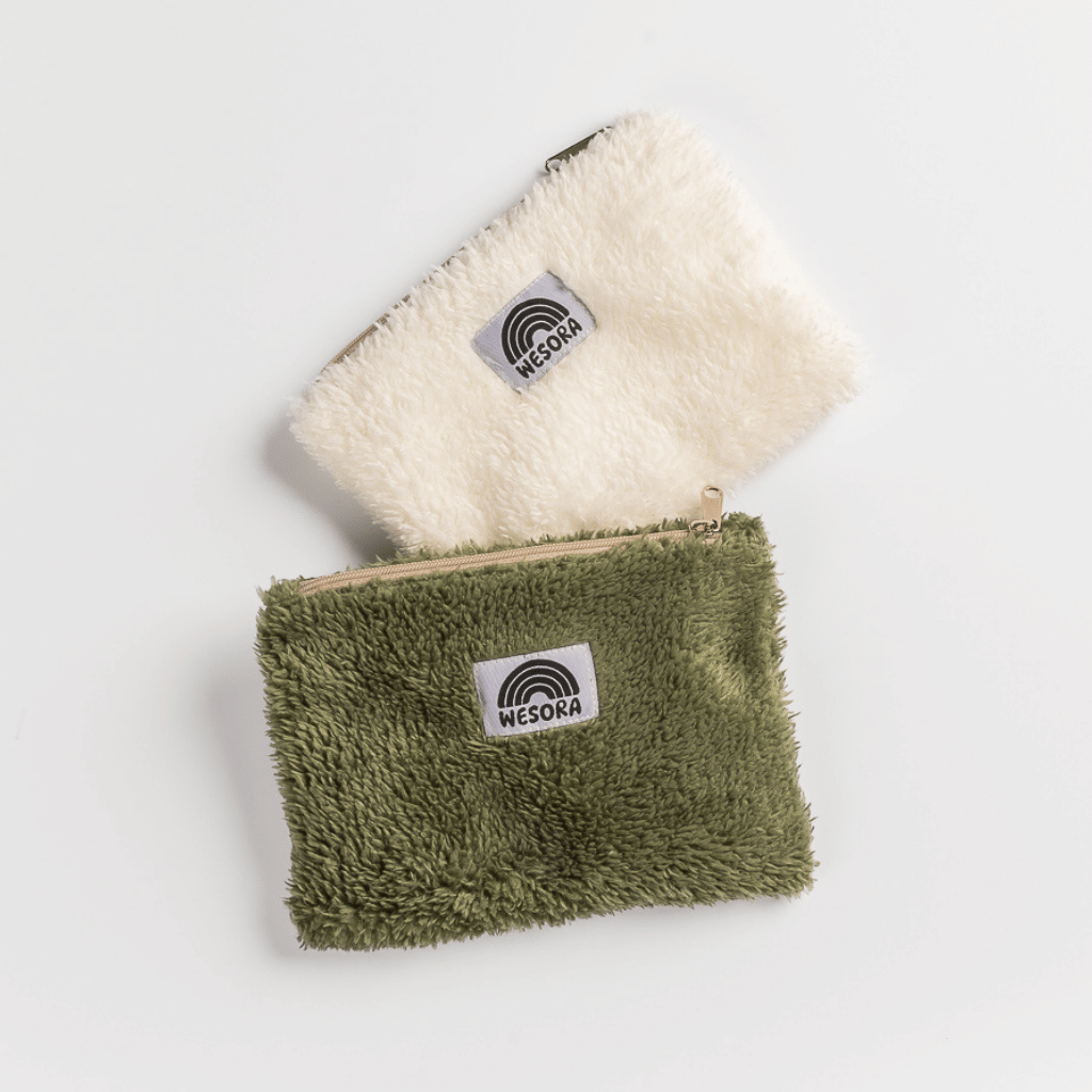 Fluffy Zip Bag - White aus sherpa-artigem Stoff mit Regenbogenlogo WESORA, liegend auf weißem Hintergrund. Perfekt für stilvolle, verantwortungsvolle Outdoor-Accessoires.