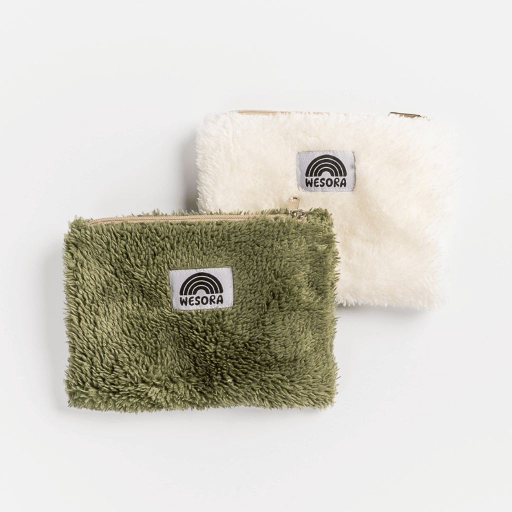 Fluffy Zip Bag - Dark Green mit einem Regenbogen-Logo-Patch, aus plüschigem Stoff, ideal für Kosmetika oder Accessoires, fotografiert in Nahaufnahme.