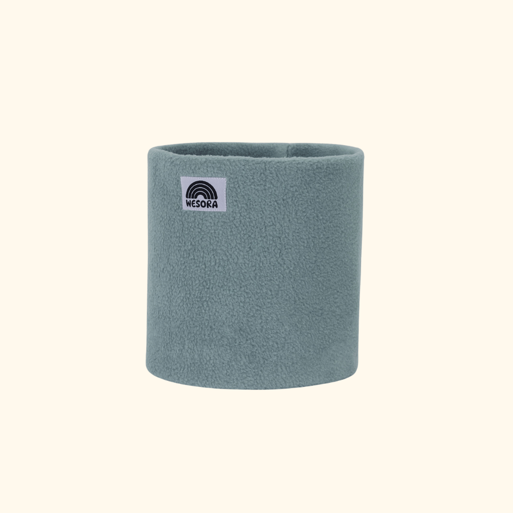 Fleece Neckwarmer - Dreamy Lilac Kid mit stilisiertem Regenbogen-Label, zylindrisch aus weichem, sherpa-ähnlichem Stoff, perfekt für winterliche Outdoor-Abenteuer.