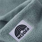 Fleece Neckwarmer - Dreamy Lilac Kid mit weichem, sagegrünem Stoff und WESORA-Tag, Nahaufnahme des handgemachten Accessoires.