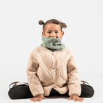 Fleece Neckwarmer - Dreamy Lilac Kid, getragen von einem sitzenden Kind mit neutralem Gesichtsausdruck, zeigt einen weichen, komfortablen Stil für winterliche Abenteuer.