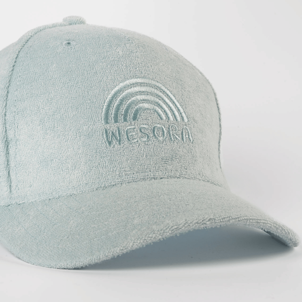 Frottee Cap - Fresh Mint mit dezentem Regenbogen-Stickmotiv WESORA, aus weichem Frottee-Stoff, fotografiert in einer frontalen Perspektive.