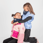 Fleece Neckwarmer -Midnight Blue Kid, getragen von lachenden Mädchen, eines kniend, in cooler Outdoor-Kleidung, vor hellem Hintergrund.