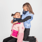Fleece Neckwarmer -Midnight Blue Kid, getragen von lachenden Mädchen, eines kniend, in cooler Outdoor-Kleidung, vor hellem Hintergrund.