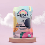 Fleece Neckwarmer -Midnight Blue Kid in einer bunten, wiederverwendbaren Verpackung mit Regenbogen-Logo und Recycling-Hinweis, auf Holzsockel vor rosa Hintergrund.