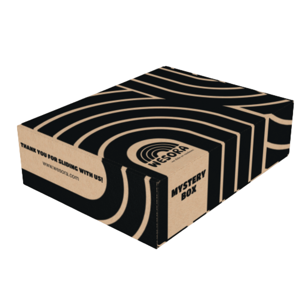 Mystery Box mit schwarzen Streifen auf Karton, enthält Neckwarmer, Socken und exklusive Beanie. Verpackung im WESORA-Design mit Logo und URL.