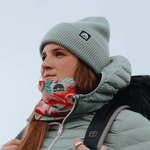 Neckwarmer & Beanie Bundle - Flamingo Green mit Flamingo- und Blattmotiven, getragen bei einer Wanderung, fotografiert in frontaler Ansicht.