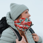 Neckwarmer & Beanie Bundle - Flamingo Green, getragen von einer Person im Profil, draußen vor einem bewölkten Himmel, mit Rucksack.