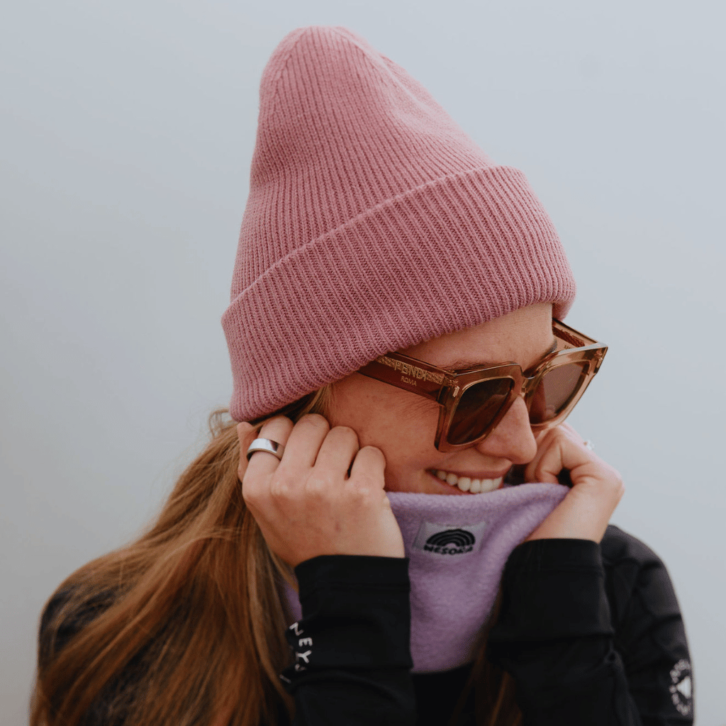 Neckwarmer & Beanie Bundle - Lilac mit geripptem Strickdesign, getragen von Person mit Sonnenbrille und langem Haar, zeigt stilvolle Wärme und Leichtigkeit.