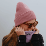 Neckwarmer & Beanie Bundle - Lilac mit geripptem Strickdesign, getragen von Person mit Sonnenbrille und langem Haar, zeigt stilvolle Wärme und Leichtigkeit.