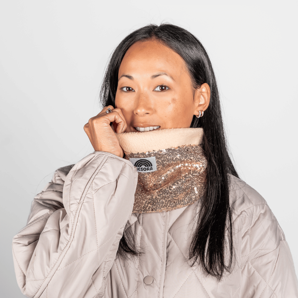 Pailetten Neckwarmer - Sparkle Gold mit funkelnden Pailletten, getragen von einem Model, fotografiert vor neutralem Hintergrund, zeigt Vorderansicht des eleganten Accessoires.