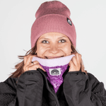 Pailetten Neckwarmer - Sparkle Lilac mit glitzerndem Fliederton und Fleecefutter, getragen von einer lächelnden Frau, betont stilvoll gegen Winterkälte.