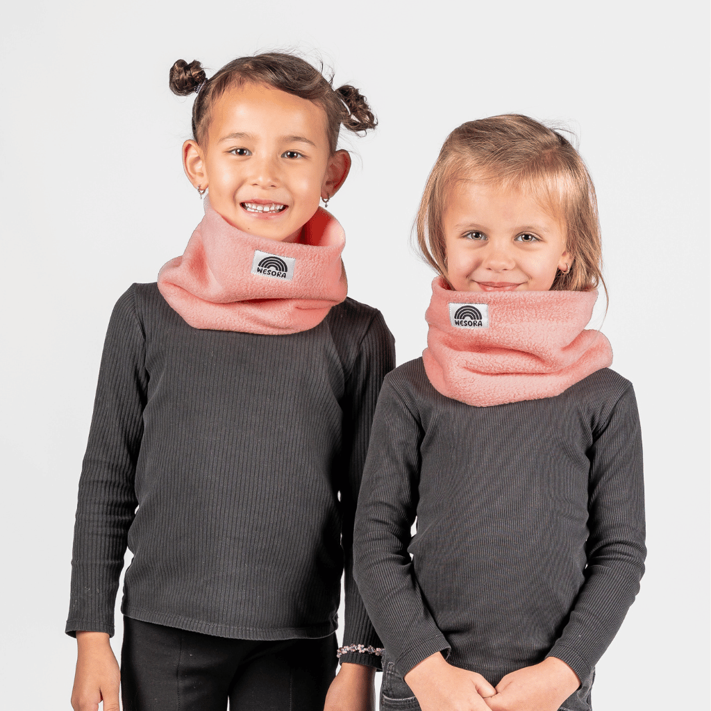Fleece Neckwarmer - Peachy Rose Kid, getragen von zwei Kindern, fotografiert vor neutralem Hintergrund, kuscheliges Accessoire für winterliches Abenteuer und Spaß.