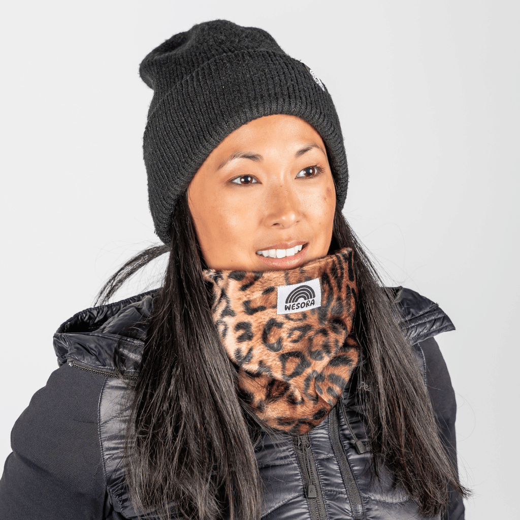 Printed Neckwarmer - Wild Leo Fur mit kräftigem Leopardenmuster, getragen von einer Frau in Winterkleidung, fotografiert frontal.