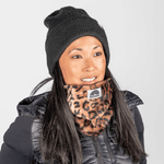 Printed Neckwarmer - Wild Leo Fur mit kräftigem Leopardenmuster, getragen von einer Frau in Winterkleidung, fotografiert frontal.