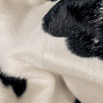 Printed Neckwarmer - Cow Spirit Fur mit Kuhmuster, weich und warm, ideal für Abenteuer im Schnee. Handgemacht in Deutschland, designt in Österreich.