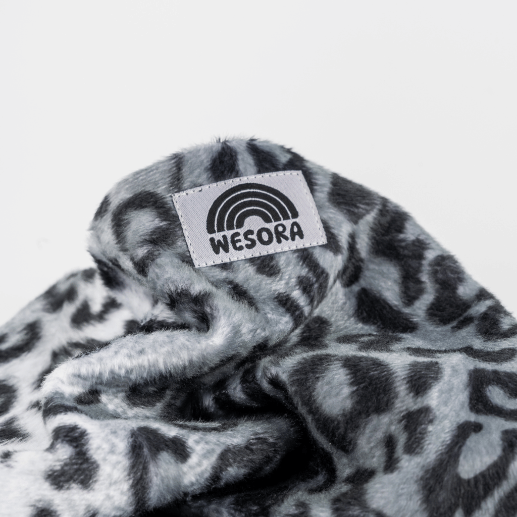 Printed Neckwarmer - Grey Leo Fur mit grauem Leopardenmuster und WESORA-Label, aus weichem Fleece, locker gefaltet fotografiert.