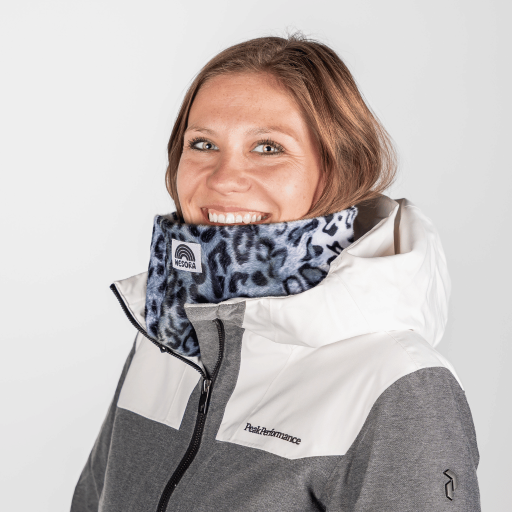 Printed Neckwarmer - Grey Leo Fur mit Leopardenmuster, getragen von einer lächelnden Person, fotografiert in einer Studioaufnahme, zeigt Stil und urbane Coolness.