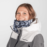 Printed Neckwarmer - Grey Leo Fur mit Leopardenmuster, getragen von einer lächelnden Person, fotografiert in einer Studioaufnahme, zeigt Stil und urbane Coolness.