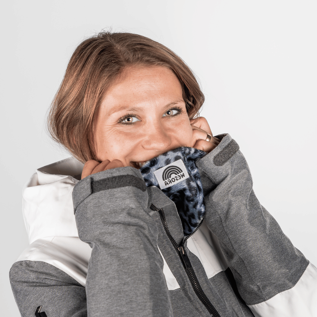 Printed Neckwarmer - Grey Leo Fur mit blauem Leopardenmuster, getragen von lächelnder Frau, betont das flauschige Fleece und sportlichen Stil.