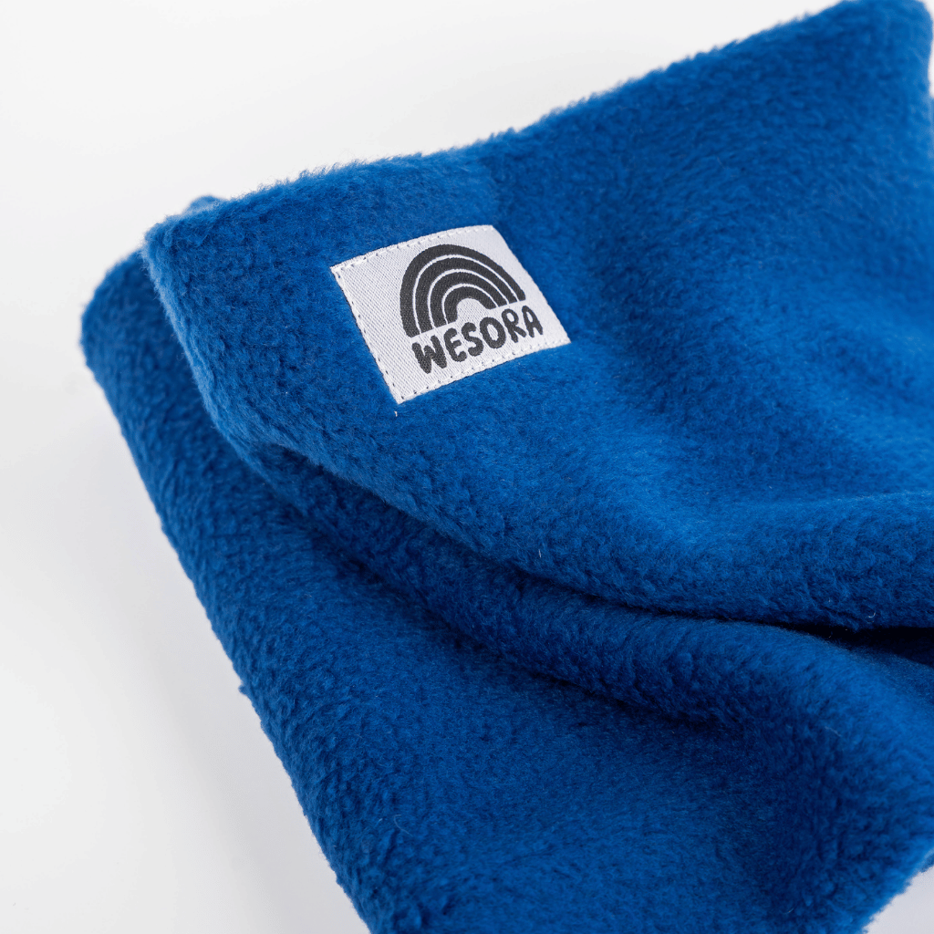 Fleece Neckwarmer - Royal Blue mit weißem WESORA-Label und Regenbogengrafik, gefaltet dargestellt. Perfekt für stilvolle Outdoor-Abenteuer.