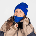 Fleece Neckwarmer - Royal Blue, getragen von einer Frau im Winterlook, die den Kragen ihrer Jacke anpasst, lächelnd in einer Outdoor-Szene.