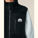Sherpa Weste - Unisex mit Reißverschluss und Brusttasche, getragen über einem langärmeligen Shirt, zeigt das WESORA-Logo mit Regenbogenmotiv.